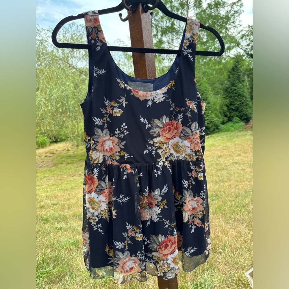 Floral pattern on a navy background sleeveless shirt sold by Sundance catalogue.